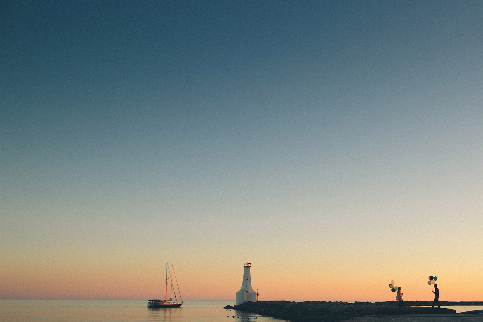 sunset lighthouse sailboat balloons engagement photo shoot